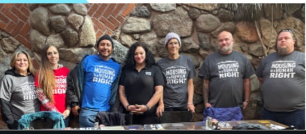 ABLE members wearing 'Housing is a Human Right' shirts at a community event
